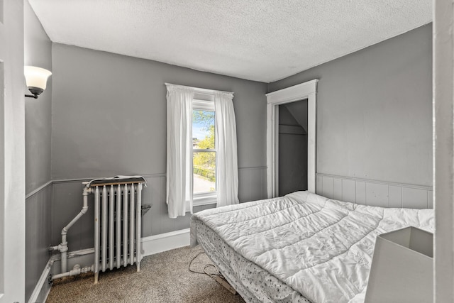 2745 Columbus Ave, Minneapolis, MN 55407 - carpeted bedroom with radiator, a textured ceiling, and wainscoting