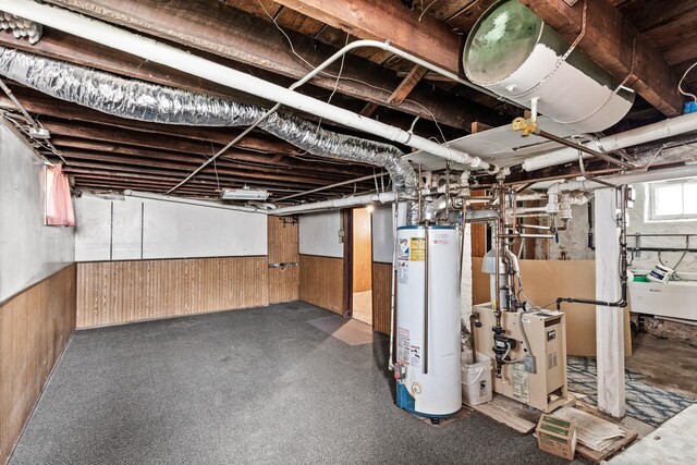 2745 Columbus Ave, Minneapolis, MN 55407 - basement with gas water heater, wooden walls, a wainscoted wall, and a heating unit