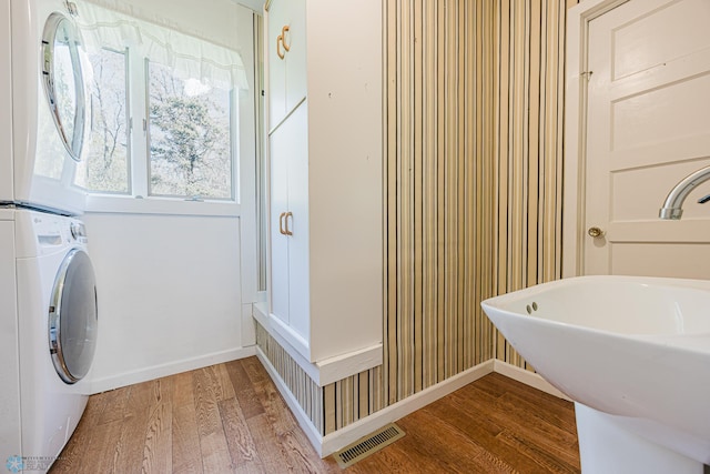 8416 141st Ave SE, Milnor, ND 58060 - bathroom with stacked washing machine and dryer, wood finished floors, a sink, and baseboards