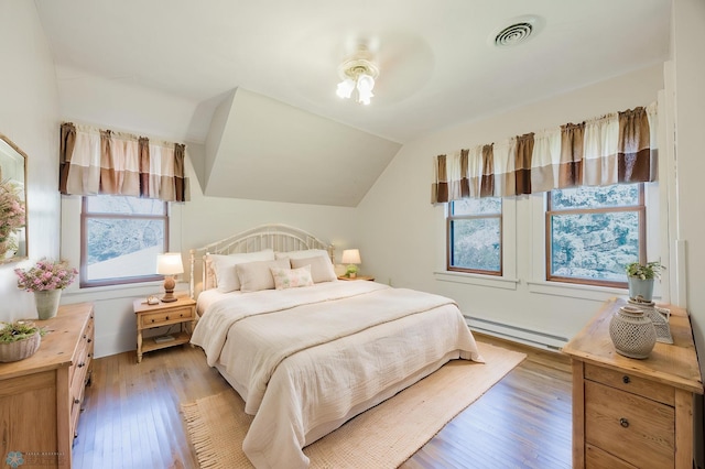 8416 141st Ave SE, Milnor, ND 58060 - bedroom featuring a baseboard heating unit, light wood-style floors, and lofted ceiling