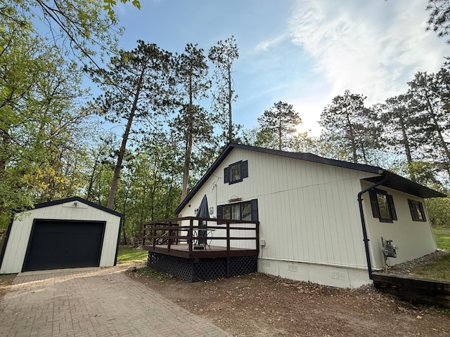 4231 Teal Ln NE, Bemidji, MN 56601 - view of side of home featuring crawl space, a wooden deck, an outdoor structure, a detached garage, and decorative driveway