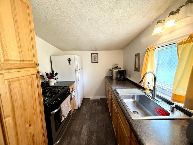 4231 Teal Ln NE, Bemidji, MN 56601 - kitchen featuring gas range, a sink, a textured ceiling, dark countertops, and dark wood finished floors