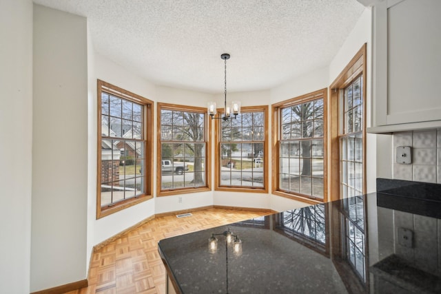 4311 Pond View Dr, White Bear Twp, MN 55110 - dining room with a textured ceiling, a chandelier, and baseboards