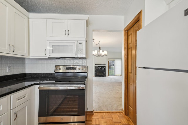 4311 Pond View Dr, White Bear Twp, MN 55110 - kitchen featuring white appliances, a chandelier, white cabinets, a textured ceiling, and backsplash