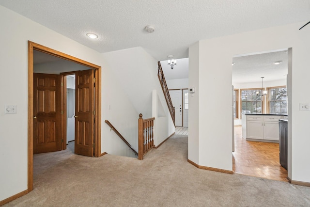 4311 Pond View Dr, White Bear Twp, MN 55110 - corridor featuring an upstairs landing, light carpet, baseboards, a textured ceiling, and a chandelier