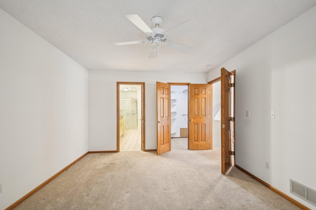4311 Pond View Dr, White Bear Twp, MN 55110 - unfurnished bedroom featuring light colored carpet, baseboards, a spacious closet, ensuite bathroom, and ceiling fan