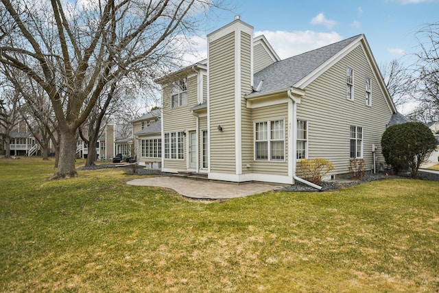 4311 Pond View Dr, White Bear Twp, MN 55110 - back of house featuring a patio, a shingled roof, a yard, and a chimney