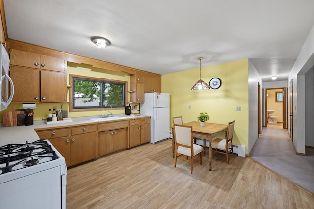 28748 Palm St NW, Isanti, MN 55040 - kitchen featuring white appliances, a sink, light countertops, and light wood-style floors