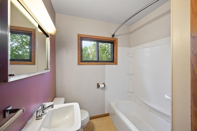 28748 Palm St NW, Isanti, MN 55040 - bathroom featuring toilet, a sink, shower / bathtub combination, and baseboards