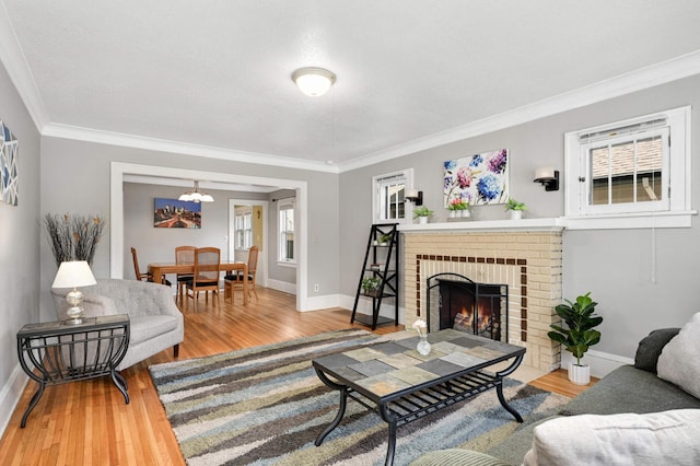 4027 24th Ave S, Minneapolis, MN 55406 - living room featuring a chandelier, ornamental molding, baseboards, wood finished floors, and a brick fireplace