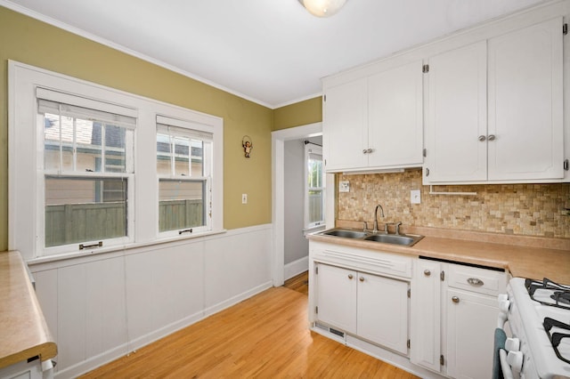 4027 24th Ave S, Minneapolis, MN 55406 - kitchen with a sink, gas range oven, white cabinets, tasteful backsplash, and light wood-style floors