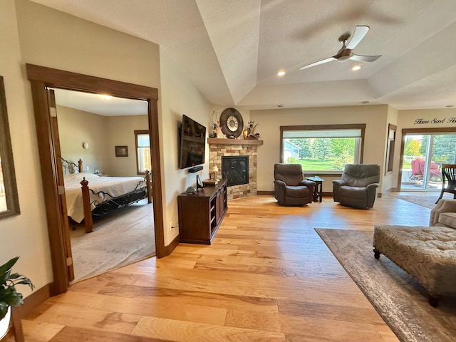 910 Lake Forest Cir, Detroit Lakes, MN 56501 - living area featuring light wood-style flooring, a ceiling fan, a stone fireplace, and baseboards
