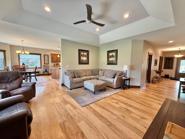 910 Lake Forest Cir, Detroit Lakes, MN 56501 - living area with light wood-type flooring, a chandelier, baseboards, ceiling fan, and a raised ceiling