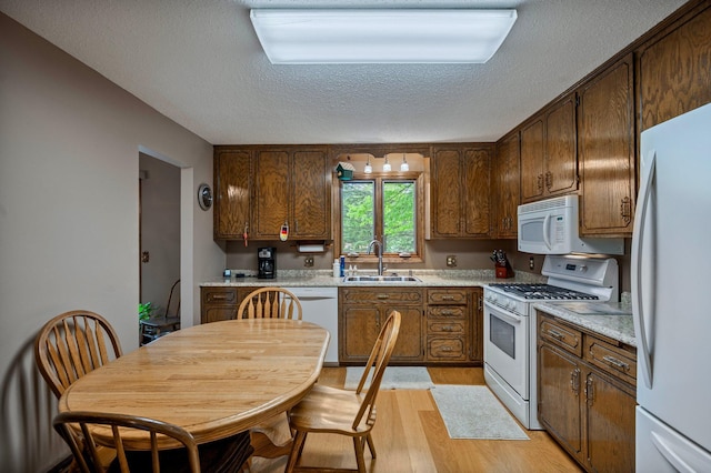 4781 Zealand Ave N, New Hope, MN 55428 - kitchen with white appliances, a textured ceiling, light wood-type flooring, and light countertops