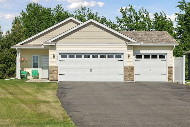 134 9th Ave NE, Isanti, MN 55040 - view of front of property featuring an attached garage, stone siding, and asphalt driveway