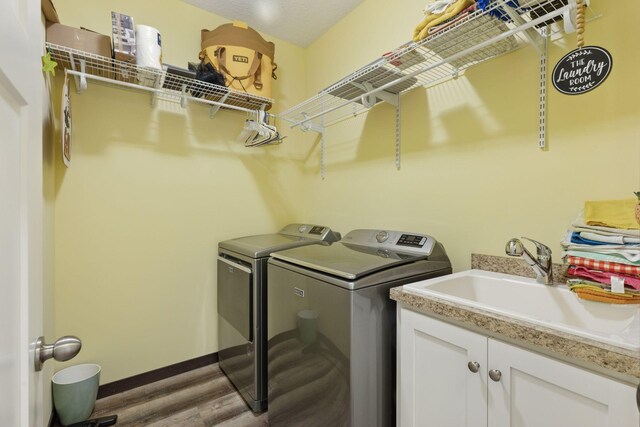 134 9th Ave NE, Isanti, MN 55040 - laundry room featuring washer and dryer, a sink, and wood finished floors