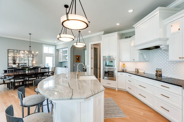 677 Shawnee Woods Rd, Medina, MN 55340 - kitchen featuring stainless steel double oven, a sink, black electric cooktop, decorative backsplash, and ornamental molding