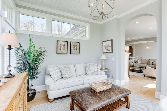 677 Shawnee Woods Rd, Medina, MN 55340 - living room featuring arched walkways, light wood-style flooring, a chandelier, ornamental molding, and recessed lighting