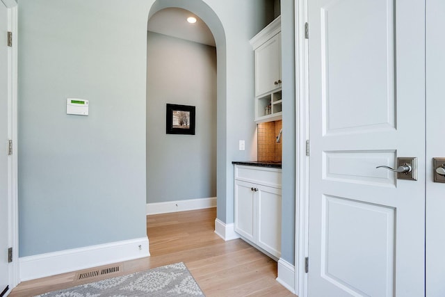 677 Shawnee Woods Rd, Medina, MN 55340 - hall featuring arched walkways, light wood finished floors, and baseboards