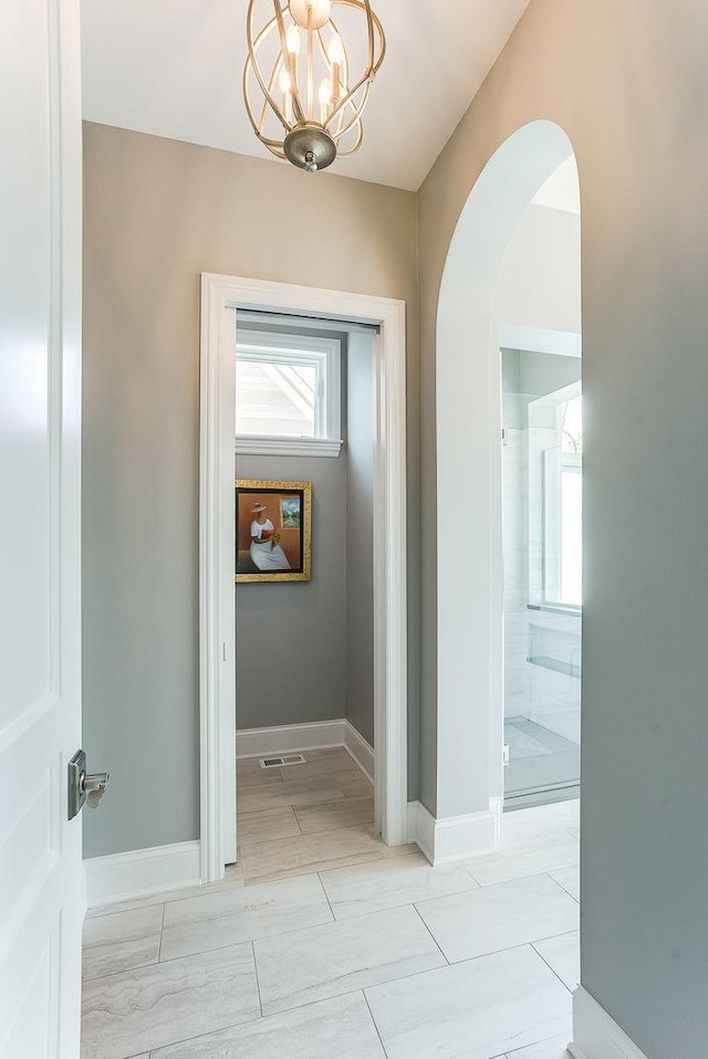 677 Shawnee Woods Rd, Medina, MN 55340 - corridor with arched walkways, baseboards, and a chandelier