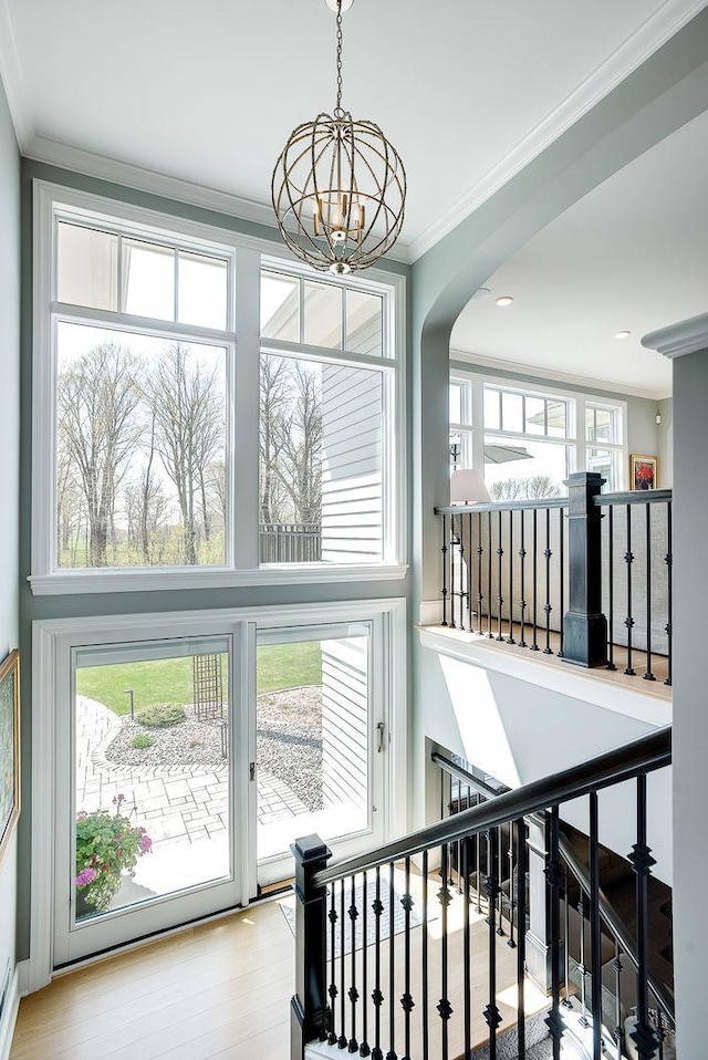 677 Shawnee Woods Rd, Medina, MN 55340 - stairway with a chandelier, crown molding, arched walkways, and wood finished floors