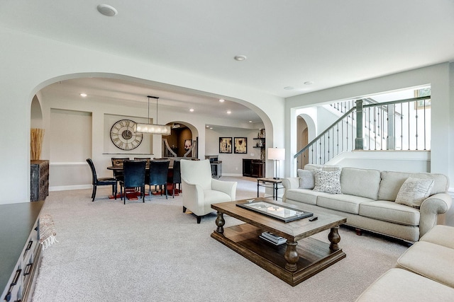 677 Shawnee Woods Rd, Medina, MN 55340 - carpeted living room featuring arched walkways, stairway, recessed lighting, and baseboards