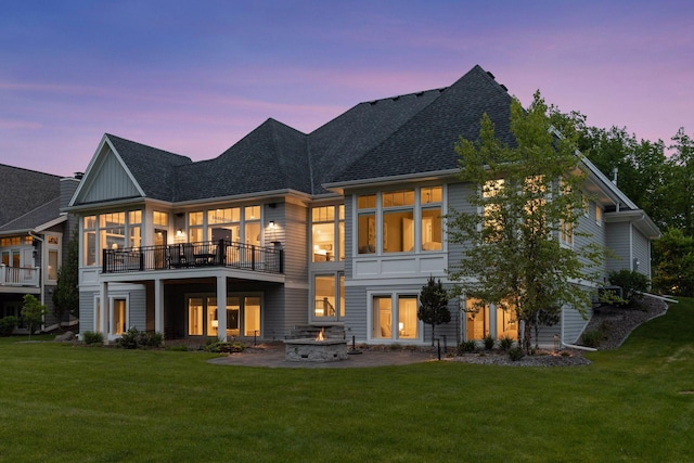 677 Shawnee Woods Rd, Medina, MN 55340 - back of property featuring a lawn, an outdoor fire pit, a shingled roof, a patio, and a wooden deck