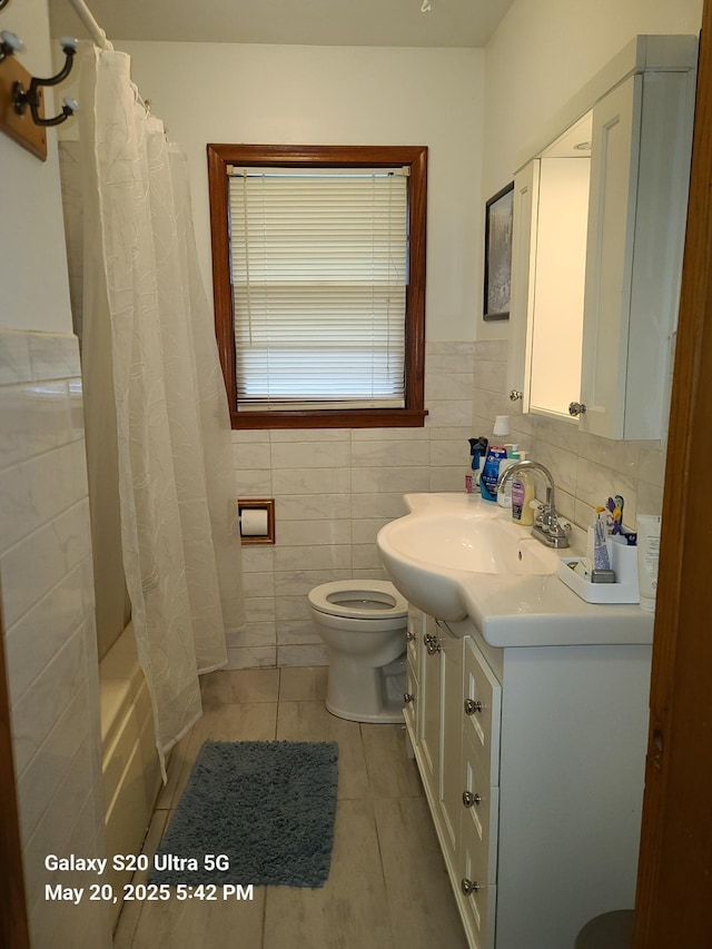 7036 Regent Ave N, Brooklyn Center, MN 55429 - full bath featuring vanity, tile patterned flooring, toilet, tile walls, and shower / bath combo