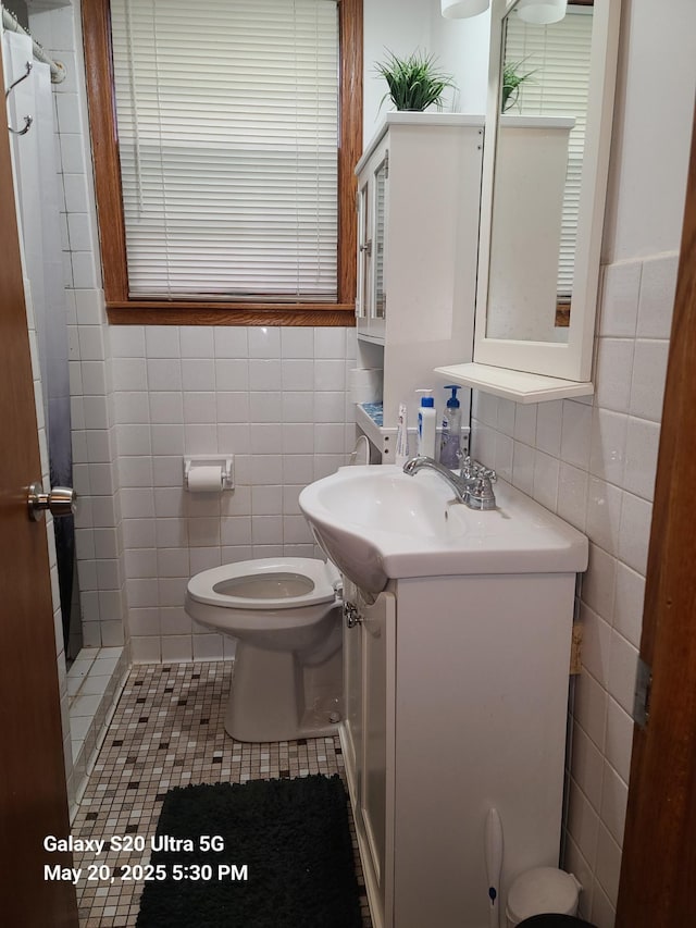 7036 Regent Ave N, Brooklyn Center, MN 55429 - bathroom featuring tile walls, vanity, a shower with curtain, toilet, and tile patterned floors