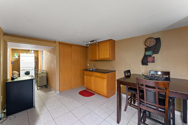 239 Buron Ln S, Saint Paul, MN 55075 - kitchen featuring stacked washer and clothes dryer, a sink, dark countertops, and light tile patterned floors