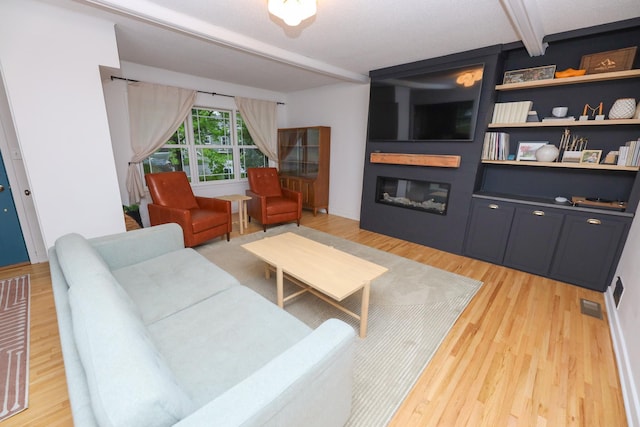 1423 Cedar St, Alexandria, MN 56308 - living area featuring beamed ceiling, a fireplace, and light wood-type flooring