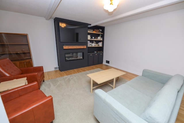 1423 Cedar St, Alexandria, MN 56308 - living area featuring a large fireplace, beam ceiling, and light wood-style floors