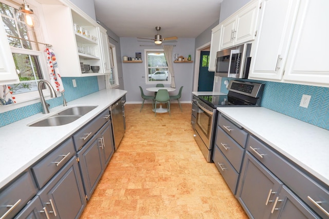 1423 Cedar St, Alexandria, MN 56308 - kitchen with appliances with stainless steel finishes, a sink, open shelves, white cabinets, and decorative backsplash