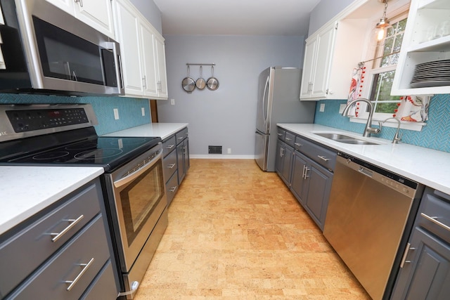 1423 Cedar St, Alexandria, MN 56308 - kitchen featuring appliances with stainless steel finishes, a sink, backsplash, and white cabinetry