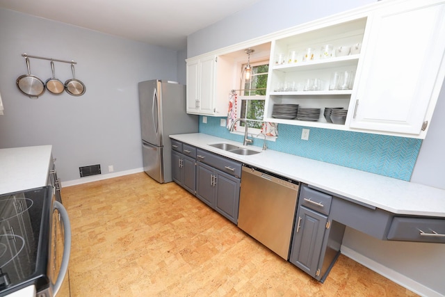 1423 Cedar St, Alexandria, MN 56308 - kitchen with stainless steel appliances, a sink, white cabinetry, decorative backsplash, and light countertops
