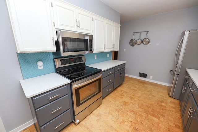 1423 Cedar St, Alexandria, MN 56308 - kitchen with stainless steel appliances, white cabinetry, decorative backsplash, and light countertops