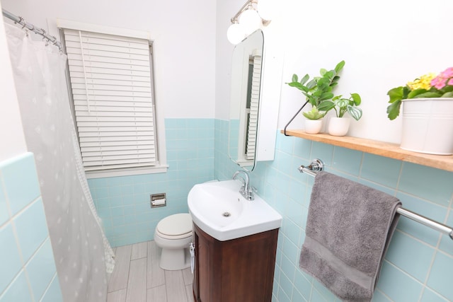 1423 Cedar St, Alexandria, MN 56308 - full bathroom with tile walls, toilet, vanity, and a wainscoted wall