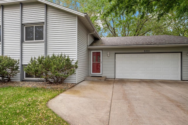 8474 Sunnyside Rd, Mounds View, MN 55112 - split level home featuring a garage, concrete driveway, a front yard, and roof with shingles