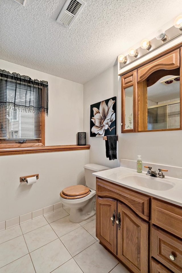 8474 Sunnyside Rd, Mounds View, MN 55112 - bathroom featuring toilet, vanity, tile patterned floors, a textured ceiling, and a shower