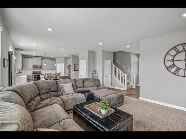 1750 Astoria Dr, Shakopee, MN 55379 - living room featuring stairs, baseboards, recessed lighting, carpet flooring, and a textured ceiling