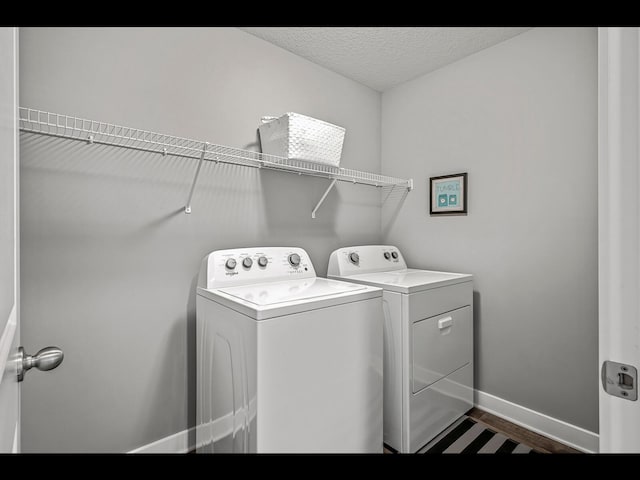 1750 Astoria Dr, Shakopee, MN 55379 - washroom featuring washing machine and clothes dryer, dark wood-style flooring, a textured ceiling, and baseboards