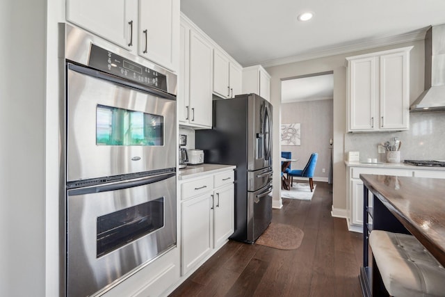 13543 Athena Way, Rosemount, MN 55068 - kitchen with appliances with stainless steel finishes, wall chimney range hood, white cabinetry, crown molding, and dark wood-style flooring