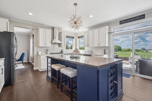 13543 Athena Way, Rosemount, MN 55068 - kitchen with wall chimney range hood, freestanding refrigerator, white cabinets, ornamental molding, and plenty of natural light