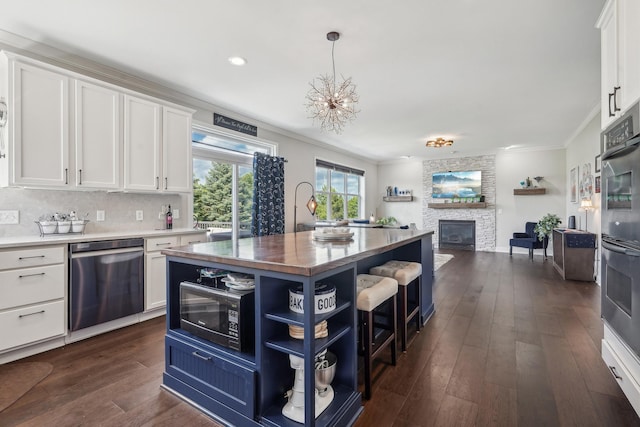 13543 Athena Way, Rosemount, MN 55068 - kitchen featuring appliances with stainless steel finishes, crown molding, white cabinetry, open floor plan, and a stone fireplace