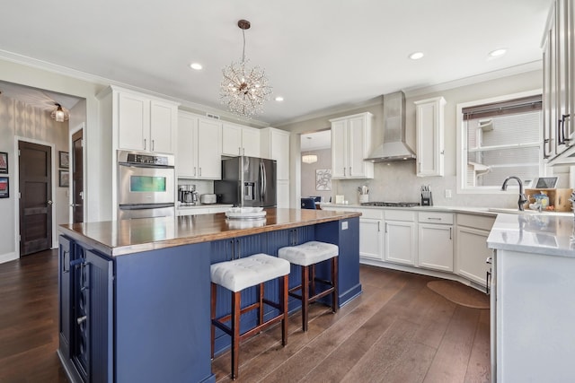 13543 Athena Way, Rosemount, MN 55068 - kitchen with wall chimney range hood, stainless steel appliances, a kitchen island, a chandelier, and white cabinetry