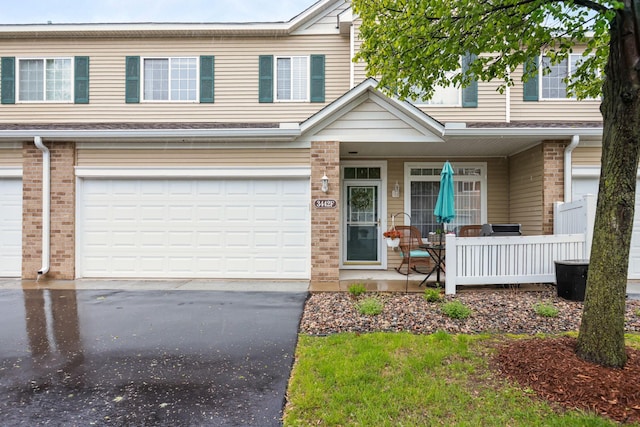 3442 Cherry Ln Unit F, Woodbury, MN 55129 - multi unit property with a porch, driveway, an attached garage, and brick siding