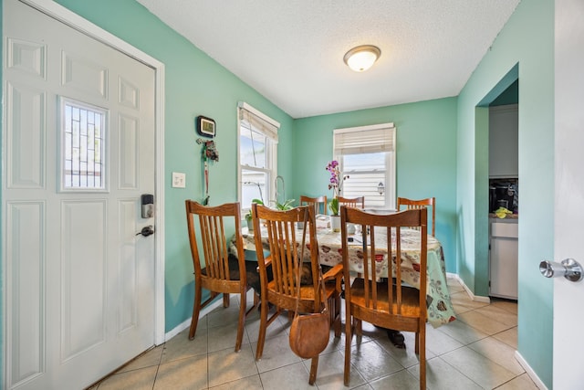 6407 Emerson Ave N, Brooklyn Center, MN 55430 - dining space with baseboards, a textured ceiling, and light tile patterned flooring