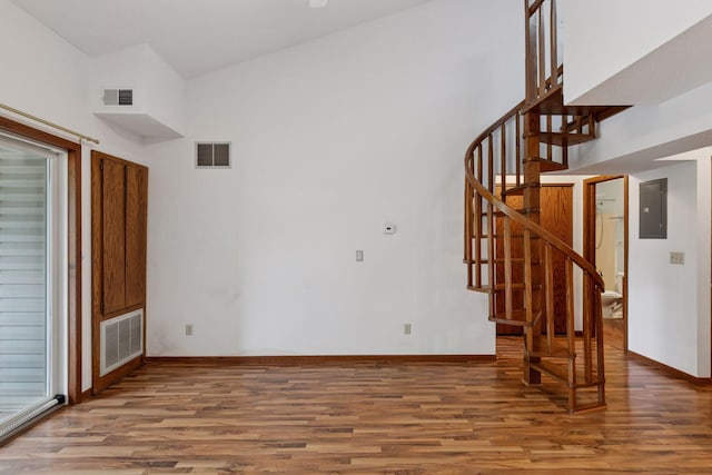 1225 Ferndale St N Unit B16, Maplewood, MN 55119 - unfurnished living room with wood finished floors, electric panel, stairway, and a high ceiling