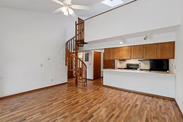 1225 Ferndale St N Unit B16, Maplewood, MN 55119 - kitchen featuring black fridge, range with electric stovetop, wood finished floors, a skylight, and brown cabinets