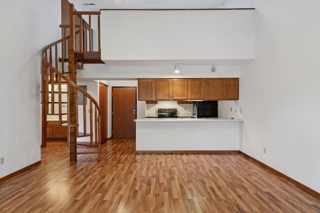 1225 Ferndale St N Unit B16, Maplewood, MN 55119 - kitchen featuring brown cabinetry, wood finished floors, baseboards, and track lighting